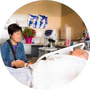 caregiver holding an senior man's hand