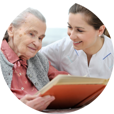 senior woman together with a nurse watching a photo album